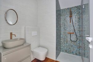 Baño principal con lavabo y mampara de ducha del apartamento duplex