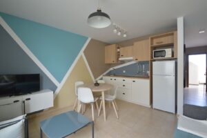 Cocina integrada en el salón del apartamento en planta baja de la urbanización Cotillo Mar