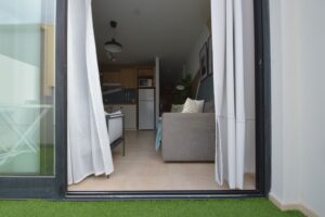 Salón con detalle de salida al jardín del apartamento en planta baja de la urbanización Cotillo Mar