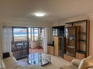 Salón con ventanales y espectaculares vistas al mar del apartamento las olas en el paseo marítimo de Corralejo