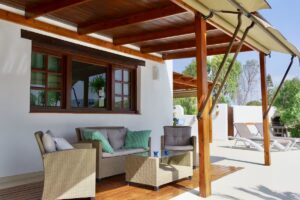 Terraza exterior con pérgola del chalet independiente de calle pared alta de Lajares