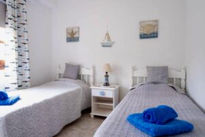 Dormitorio con dos camas del chalet independiente de calle pared alta de Lajares
