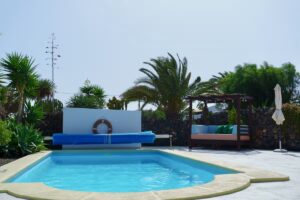 Vista de frente de la piscina del chalet independiente de calle pared alta de Lajares
