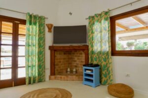 Salón y detalle de chimenea y televisión del chalet independiente de calle pared alta de Lajares