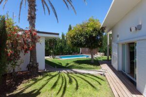 Jardín lateral con vista de la piscina particular del chalet de lujo en Corralejo