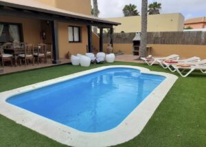 Piscina y fachada de chalet independiente de la calle Guirre en Corralejo.