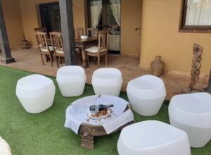 Detalle de mesa baja y pubs en el jardín del chalet independiente de la calle Guirre en Corralejo.