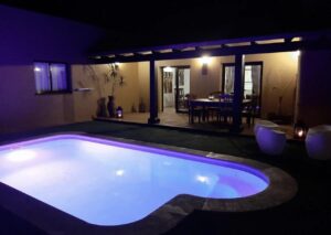 Piscina y detalle de de iluminación nocturna de chalet independiente de la calle Guirre en Corralejo.