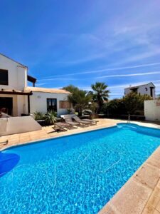 Perspectiva de la fachada principal junto con la piscina del chalet independiente de la calle Paradejas en Lajares