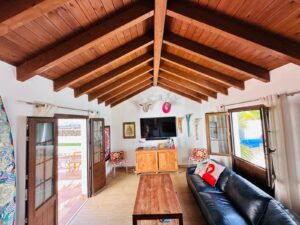 Salón con espectaculares vigas de madera en techo del chalet independiente de la calle Paradejas en Lajares