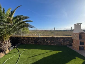 Perspectiva del exterior de la casa con detalles de palmeras de la Villa en calle del jable de Lajares.