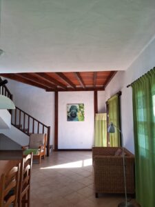 Perspectiva diferente del salón con escalera al fondo de la Villa con cuatro apartamentos independientes en Lajares