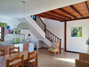 Salón con detalles de la escalera para subir a la planta de arriba de la Villa con cuatro apartamentos independientes en Lajares