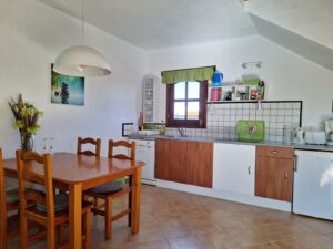 Cocina con mesa de comedor de uno del os apartamentos independientes con detalle de armarios de la Villa con cuatro apartamentos independientes en Lajares