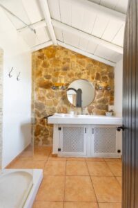 Precioso baño con detalles de espejo y pared rústicos de la calle central de Lajares, Fueteventura