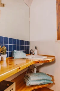 Detalle de lavabos de madera con color claro del otro baño de la casa.