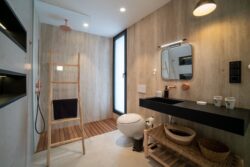 Baño principal de Villa Gaia con azulejos claros y muebles de madera en Fuerteventura.