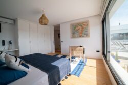 Habitación luminosa con grandes ventanales y acceso directo a la terraza en Villa Gaia, Fuerteventura.