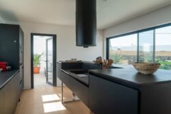 Cocina moderna de concepto abierto con isla central en Villa Gaia, Fuerteventura.