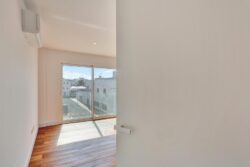 Entrada al salón viéndose los ventanales con vistas al exterior de los apartamentos de planta alta del edificio de 4 apartamentos en El Cotillo