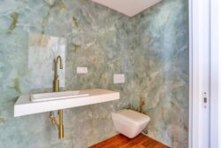 Baño con modernos sanitarios y detalle decoración paredes de los apartamentos de planta alta del edificio de 4 apartamentos en El Cotillo