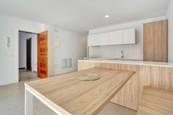 Detalle de mesa abierta para usar de comedor en la cocina de los apartamentos de planta baja del edificio en El Cotillo