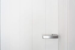Puerta blanca con pomo de color plata con detalle de calidades en los apartamentos de planta baja del edificio de 4 apartamentos en El Cotillo